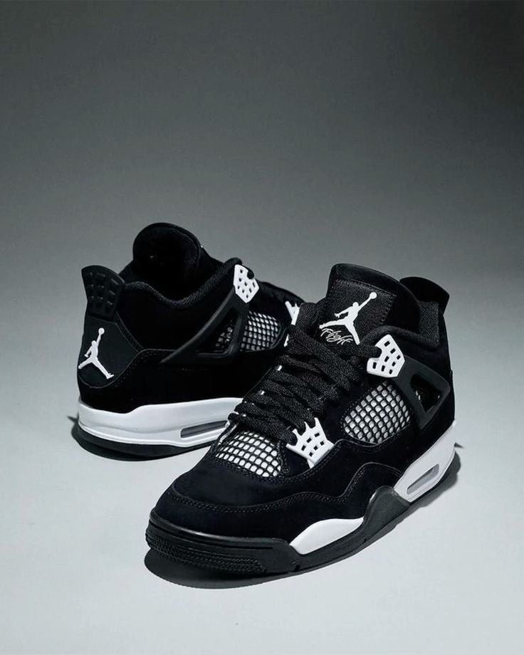 Air Jordan 4 "White Thunder" sneakers, featuring a sleek black nubuck upper contrasted by crisp white mesh accents