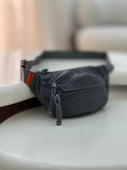 Nylon fanny pack with double zippered compartments and braided zipper pulls.