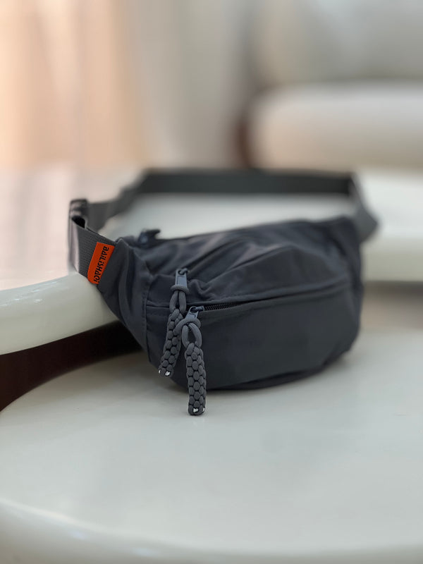 Nylon fanny pack with double zippered compartments and braided zipper pulls.