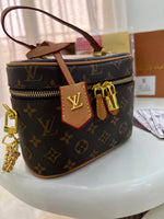 Louis Vuitton Vanity PM crafted in the iconic Monogram coated canvas with a top handle, gold-tone zipper, and a small padlock