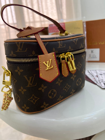 Louis Vuitton Vanity PM crafted in the iconic Monogram coated canvas with a top handle, gold-tone zipper, and a small padlock