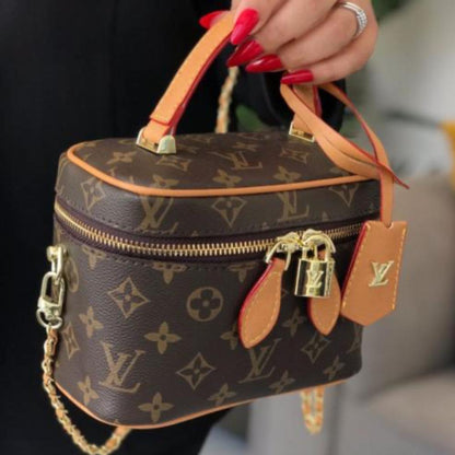 Louis Vuitton Vanity PM crafted in the iconic Monogram coated canvas with a top handle, gold-tone zipper, and a small padlock