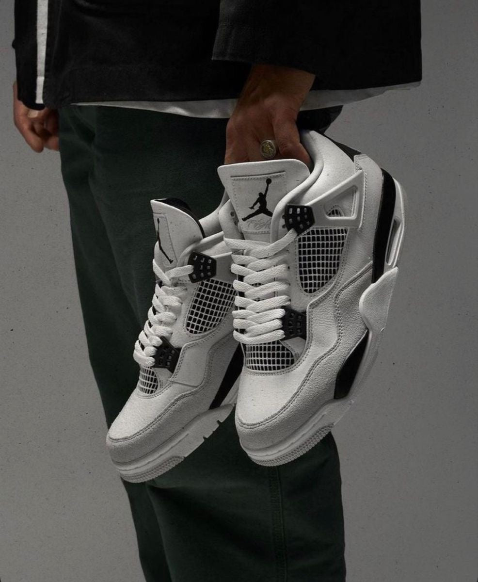 Air Jordan 4 Retro "Military Black" sneakers, highlighted by their crisp white leather upper and contrasting neutral grey mudguard