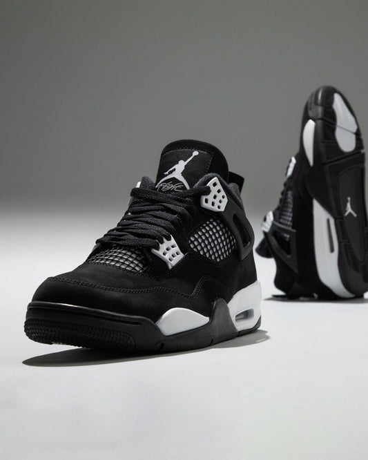 Air Jordan 4 "White Thunder" sneakers, featuring a sleek black nubuck upper contrasted by crisp white mesh accents
