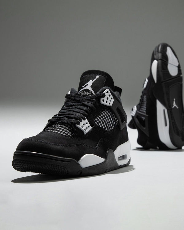Air Jordan 4 "White Thunder" sneakers, featuring a sleek black nubuck upper contrasted by crisp white mesh accents