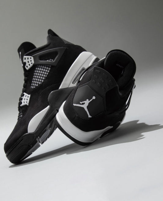 Air Jordan 4 "White Thunder" sneakers, featuring a sleek black nubuck upper contrasted by crisp white mesh accents