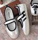 Samba Jane sneakers in white and black, featuring a distinctive midfoot strap and delicate ruffled trim