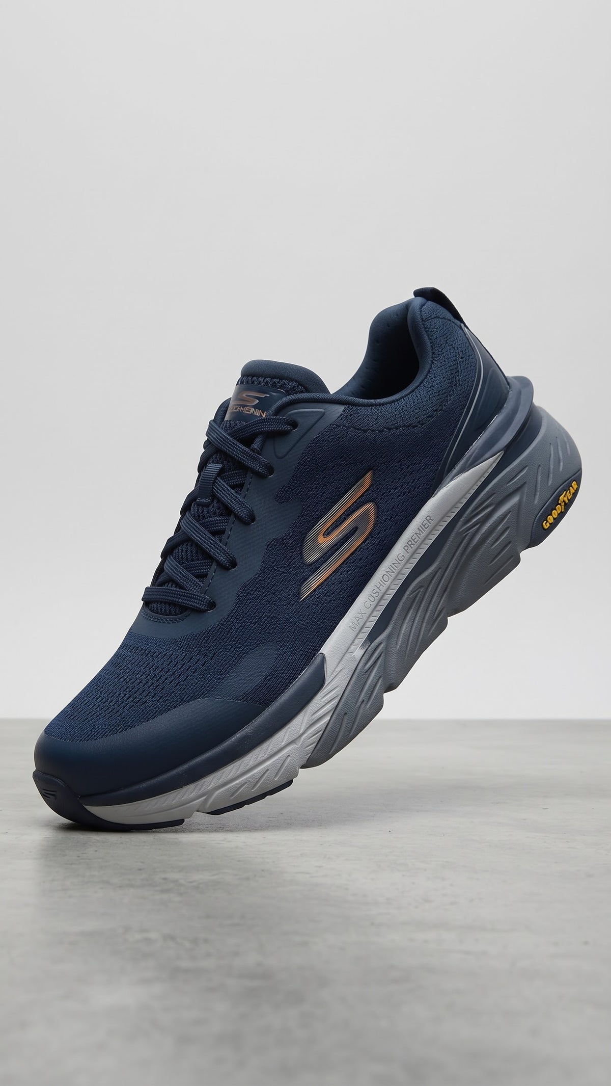 Skechers Max Cushioning athletic shoe featuring bright orange accents and a durable Goodyear rubber outsole