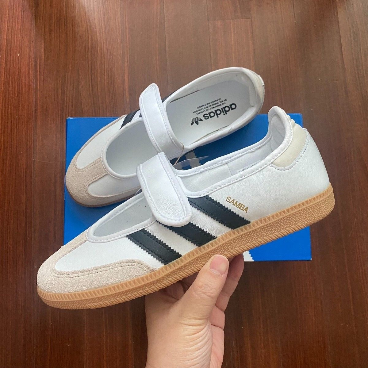 Samba Jane shoes featuring a white leather upper, black stripes, and a velcro strap