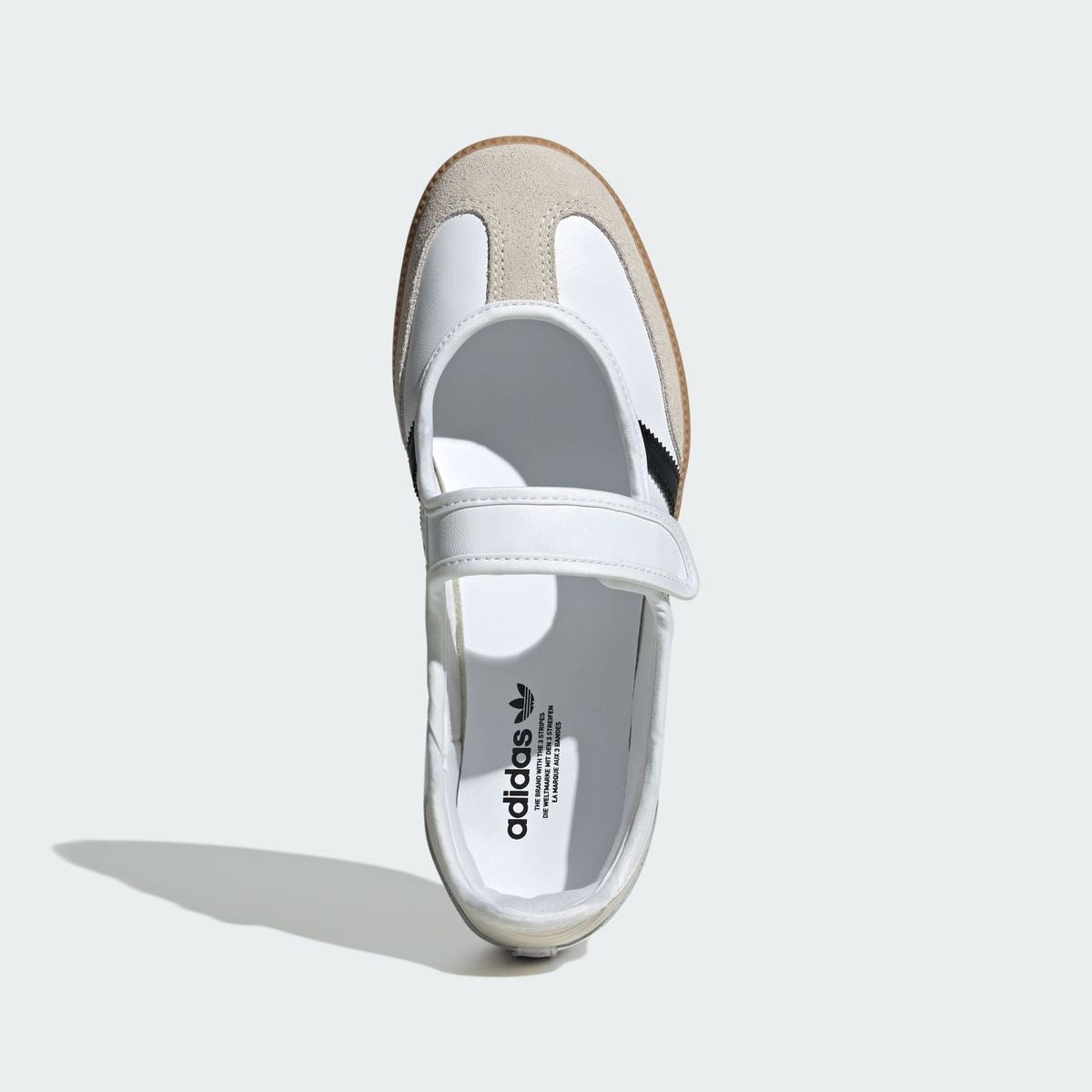Samba Jane shoes featuring a white leather upper, black stripes, and a velcro strap