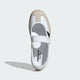 Samba Jane shoes featuring a white leather upper, black stripes, and a velcro strap