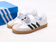 Samba Jane shoes featuring a white leather upper, black stripes, and a velcro strap