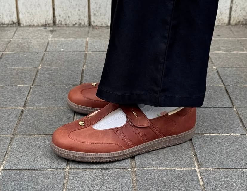 Samba Mary Jane-style strap shoes in a "Brown" or "Sand Strata" colorway, featuring a unique